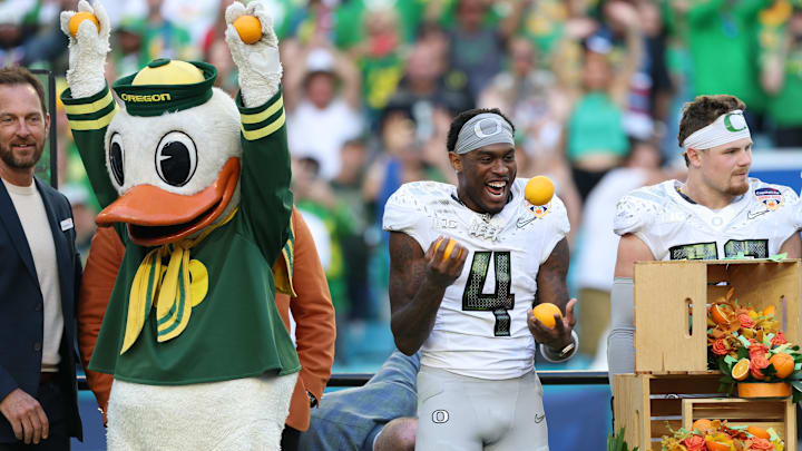 Jan 1, 2026; Miami Gardens, FL, USA; Oregon Ducks wide receiver Malik Benson (4) juggles oranges while “The Duck” celebrates following the 2025 Orange Bowl and quarterfinal game of the College Football Playoff against the Texas Tech Red Raiders at Hard Rock Stadium. Mandatory Credit: Nathan Ray Seebeck-Imagn Images