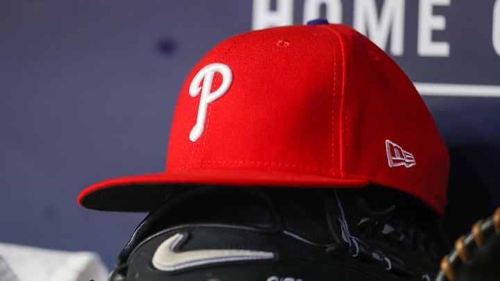 May 26, 2023; Atlanta, Georgia, USA; A detailed view of a Philadelphia Phillies hat and glove on the bench against the Atlanta Braves in the seventh inning at Truist Park. Mandatory Credit: Brett Davis-Imagn Images