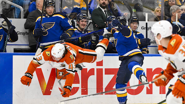 Jan 9, 2025; St. Louis, Missouri, USA;  St. Louis Blues left wing Nathan Walker (26) checks Anaheim Ducks defenseman Drew Helleson (43) during the second period at Enterprise Center. Mandatory Credit: Jeff Curry-Imagn Images