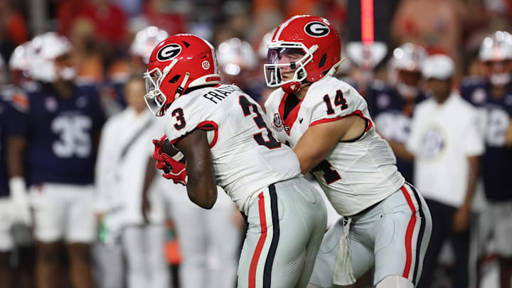Oct 11, 2025; Auburn, Alabama, USA; Georgia Bulldogs quarterback Gunner Stockton (14) hands off to running back Nate Frazier (3) during the first quarter against the Auburn Tigers at Jordan-Hare Stadium. Mandatory Credit: John Reed-Imagn Images Oct 11, 2025; Auburn, Alabama, USA; Georgia Bulldogs quarterback Gunner Stockton (14) hands off to running back Nate Frazier (3) during the first quarter against the Auburn Tigers at Jordan-Hare Stadium. Mandatory Credit: John Reed-Imagn Images