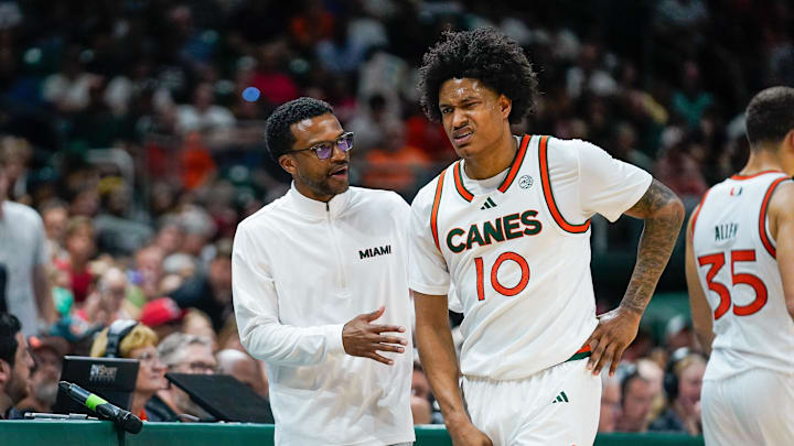Mar 7, 2026; Coral Gables, Florida, USA; Miami Hurricanes head coach Jai Lucas talks to guard Tru Washington (10) after a foul against the Louisville Cardinals during the second half at Watsco Center. Mandatory Credit: Jeff Romance-Imagn Images