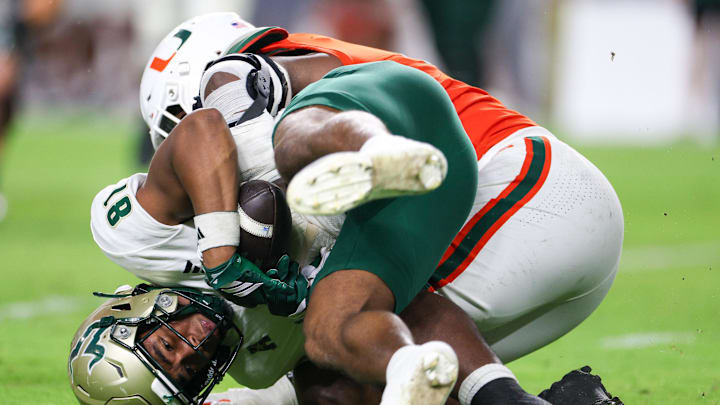 Sep 13, 2025; Miami Gardens, Florida, USA; Miami Hurricanes defensive lineman Rueben Bain Jr. (4) tackles South Florida Bulls wide receiver Christian Neptune (81) in the third quarter at Hard Rock Stadium. Mandatory Credit: Nathan Ray Seebeck-Imagn Images