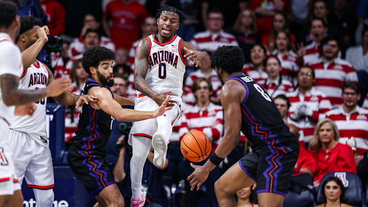 Dec 30, 2024; Tucson, Arizona, USA; Arizona Wildcats guard Jaden Bradley (0) loses control over the ball as TCU Horned Frogs guard Noah Reynolds (21) and TCU Horned Frogs center Ernest Udeh Jr. (8) attempt to grab the ball during the first half of the game at McKale Center.