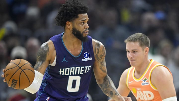Dec 22, 2025; Cleveland, Ohio, USA; Charlotte Hornets forward Miles Bridges (0) looks to pass beside Cleveland Cavaliers guard Sam Merrill (5) in the first quarter at Rocket Arena. Mandatory Credit: David Richard-Imagn Images