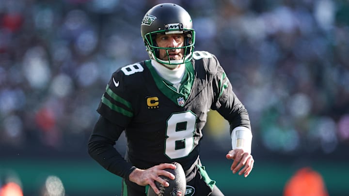 Dec 1, 2024; East Rutherford, New Jersey, USA; New York Jets quarterback Aaron Rodgers (8) scrambles during the first quarter against the New York Jets at MetLife Stadium.