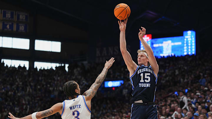 Jan 31, 2026; Lawrence, Kansas, USA; BYU Cougars guard Richie Saunders (15) shoots against Kansas Jayhawks guard Tre White (3) during the first half at Allen Fieldhouse. Mandatory Credit: Jay Biggerstaff-Imagn Images Jan 31, 2026; Lawrence, Kansas, USA; BYU Cougars guard Richie Saunders (15) shoots against Kansas Jayhawks guard Tre White (3) during the first half at Allen Fieldhouse. Mandatory Credit: Jay Biggerstaff-Imagn Images