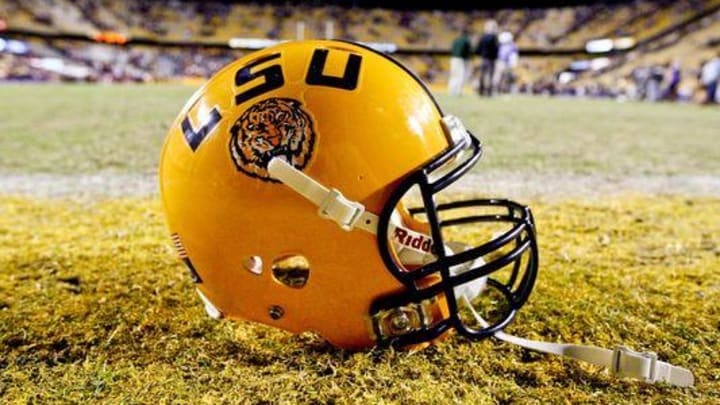 A member of the LSU football team is accused of harboring two murder suspects in his dorm room.