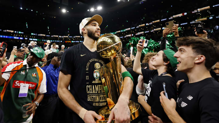 Jun 17, 2024; Boston, Massachusetts, USA; Boston Celtics forward Jayson Tatum (0) walks off the court with the trophy as he celebrates winning the 2024 NBA Finals against the Dallas Mavericks at TD Garden. Mandatory Credit: Peter Casey-USA TODAY Sports