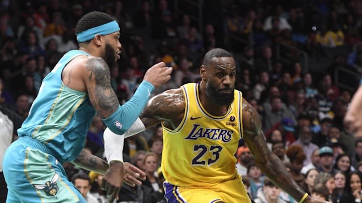 Feb 5, 2024; Charlotte, North Carolina, USA;  Los Angeles Lakers forward LeBron James (23) drives past Charlotte Hornets forward Miles Bridges (0) during the first half at the Spectrum Center. Mandatory Credit: Sam Sharpe-Imagn Images
