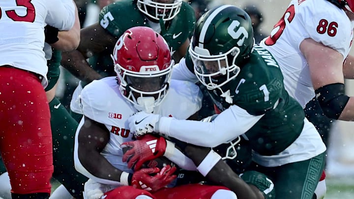 Nov 30, 2024; East Lansing, Michigan, USA; Rutgers Scarlet Knights running back Kyle Monangai (5) is tackled by Michigan State Spartans defensive back Nikai Martinez (1) and linebacker Jordan Turner (7) during the first quarter at Spartan Stadium. Mandatory Credit: Dale Young-Imagn Images Nov 30, 2024; East Lansing, Michigan, USA; Rutgers Scarlet Knights running back Kyle Monangai (5) is tackled by Michigan State Spartans defensive back Nikai Martinez (1) and linebacker Jordan Turner (7) during the first quarter at Spartan Stadium. Mandatory Credit: Dale Young-Imagn Images