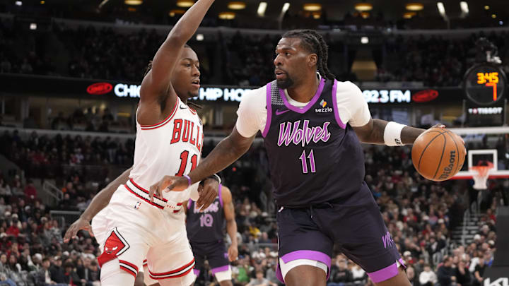 Dec 29, 2025; Chicago, Illinois, USA; Chicago Bulls guard Ayo Dosunmu (11) defends Minnesota Timberwolves center Naz Reid (11) during the first half at United Center. Mandatory Credit: David Banks-Imagn Images