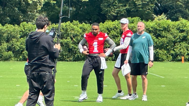 Jalen Hurts (left), with Tanner McKee, gets instruction from quarterbacks coach Scot Loeffler during the Eagles' minicamp on June 10, 2025.