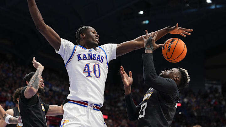Dec 16, 2025; Lawrence, Kansas, USA; Kansas Jayhawks forward Flory Bidunga (40) and Towson Tigers forward Caleb Embeya (23) fight for a rebound during the second half at Allen Fieldhouse. Mandatory Credit: Jay Biggerstaff-Imagn Images
