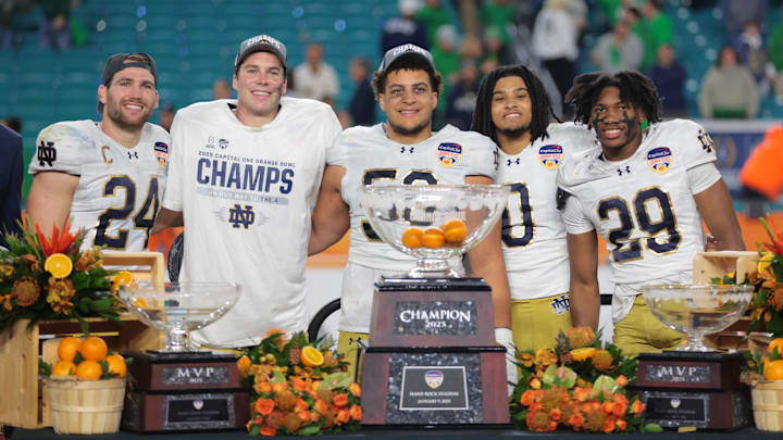 Jan 9, 2025; Miami, FL, USA; Notre Dame Fighting Irish linebacker Jack Kiser (24) defensive lineman Howard Cross III (56) safety Xavier Watts (0) and quarterback Riley Leonard (13) and cornerback Christian Gray (29) celebrate deafening the Penn State Nittany Lions in the Orange Bowl at Hard Rock Stadium. Mandatory Credit: Sam Navarro-Imagn Images