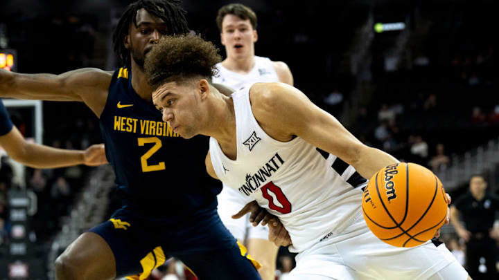 Cincinnati Bearcats guard Dan Skillings Jr. (0) drives on West Virginia Mountaineers guard Kobe Johnson (2) in the first half of the Big 12 Conference tournament between Cincinnati Bearcats and West Virginia Mountaineers at T-Mobile Center in Kansas City, Mo., on Tuesday, March 12, 2024.