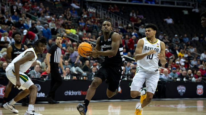 Cincinnati Bearcats guard Jizzle James (2) drives on Baylor Bears guard RayJ Dennis (10) in the second half of the Big 12 Conference tournament game between Cincinnati Bearcats and Baylor Bears at T-Mobile Center in Kansas City, Mo., on Thursday, March 14, 2024.