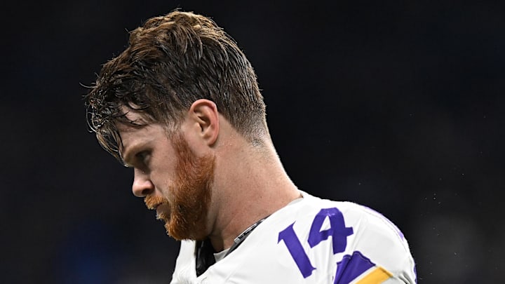 Jan 5, 2025; Detroit, Michigan, USA; Minnesota Vikings quarterback Sam Darnold (14) adjusts his uniform off his shoulder pads while walking off the field after taking a hit on a fourth down pass attempt that fell incomplete against the Detroit Lions in the fourth quarter at Ford Field. Mandatory Credit: Lon Horwedel-Imagn Images