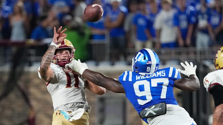 Aug 28, 2025; Durham, North Carolina, USA; Elon Phoenix quarterback Landen Clark (11) is hit by Duke Blue Devils defensive end Wesley Williams (97) on his pass during the second half at Wallace Wade Stadium. Mandatory Credit: James Guillory-Imagn Images
