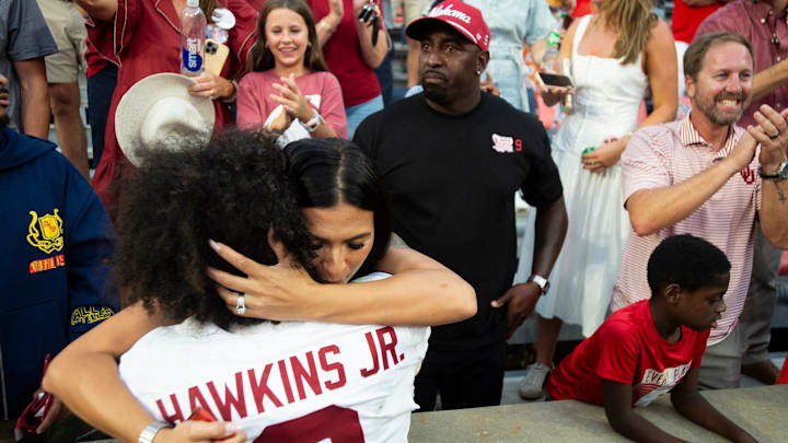 Oklahoma Sooners quarterback Michael Hawkins Jr. (9) hugs his mom, Annabelle, while Mike Hawkins Sr. watches.