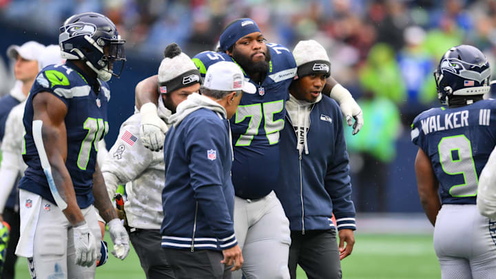 Nov 24, 2024; Seattle, Washington, USA; Seattle Seahawks guard Anthony Bradford (75) is helped off the field during the first half against the Arizona Cardinals at Lumen Field.