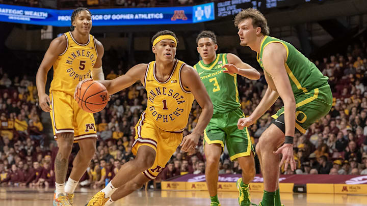 Jan 25, 2025; Minneapolis, Minnesota, USA; Minnesota Golden Gophers guard Isaac Asuma (1) drives to the basket as Oregon Ducks center Nate Bittle (32) defends during the first half at Williams Arena. Mandatory Credit: Nick Wosika-Imagn Images