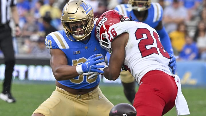 Nov 30, 2024; Pasadena, California, USA; UCLA Bruins linebacker Joseph Vaughn (30) breaks up a pass intended for Fresno State Bulldogs linebacker Tim Thomas (26) during the second quarter at Rose Bowl. Mandatory Credit: Robert Hanashiro-Imagn Images