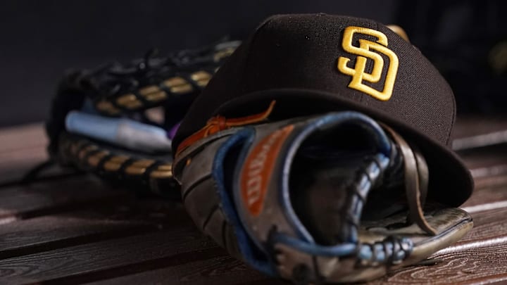 Jul 23, 2021; Miami, Florida, USA; A general view of a San Diego Padres hat and glove in the dugout prior to the game between the Miami Marlins and the San Diego Padres at loanDepot park. Mandatory Credit: Jasen Vinlove-Imagn Images