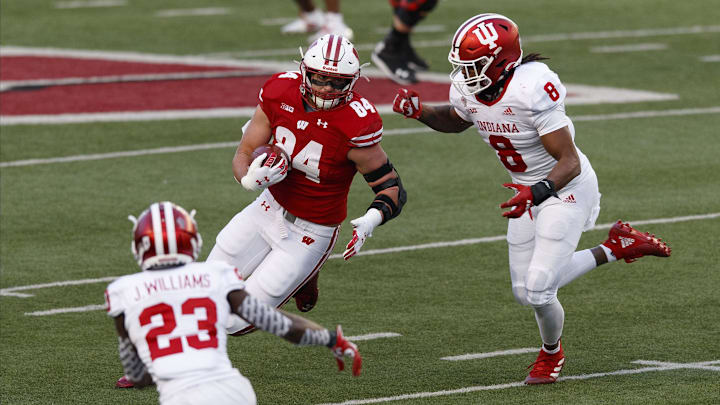 Dec 5, 2020; Madison, Wisconsin, USA;  Wisconsin Badgers tight end Jake Ferguson (84) rushes with the football after catching a pass as Indiana Hoosiers linebacker James Miller (8) defends during the second quarter at Camp Randall Stadium.