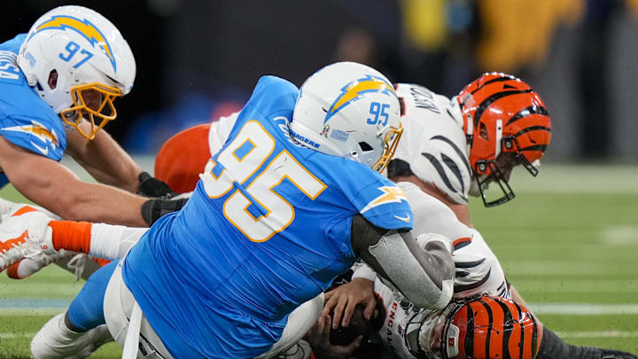 Nov 17, 2024; Inglewood, CA, USA; Cincinnati Bengals quarterback Joe Burrow (9) is sacked by Los Angeles Chargers defensive tackle Poona Ford (95) in the second quarter of the NFL Week 11 game between the Los Angeles Chargers and the Cincinnati Bengals at SoFi Stadium in Inglewood, Calif., on Sunday, Nov. 17, 2024. The Chargers led 24-6 at halftime. Mandatory Credit: Sam Greene/USA TODAY Network via Imagn Images 