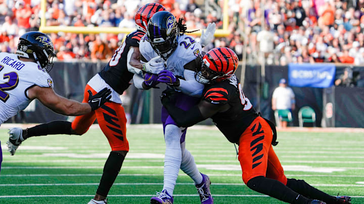 Cincinnati Bengals cornerback DJ Turner II (20), left and defensive end Myles Murphy (99) take down Baltimore Ravens running back Derrick Henry (22) during the 4th quarter Sunday October 6, 2024 at Payor Stadium. The Bengals lost to Baltimore Ravens 41-38 in overtime.
