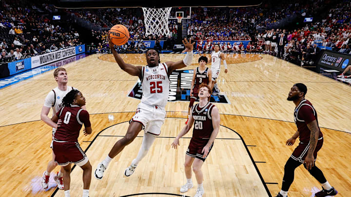 Mar 20, 2025; Denver, CO, USA; Wisconsin Badgers guard John Blackwell (25) drives to the net as Montana Grizzlies guard Money Williams (0) defends against forward Steven Crowl (22) and guard Austin Patterson (20) and forward Te'Jon Sawyer (32) defend in the first half at Ball Arena. Mar 20, 2025; Denver, CO, USA; Wisconsin Badgers guard John Blackwell (25) drives to the net as Montana Grizzlies guard Money Williams (0) defends against forward Steven Crowl (22) and guard Austin Patterson (20) and forward Te'Jon Sawyer (32) defend in the first half at Ball Arena.