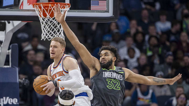 Nov 20, 2023; Minneapolis, Minnesota, USA; New York Knicks guard Donte DiVincenzo (0) looks to pass as Minnesota Timberwolves center Karl-Anthony Towns (32) defends in the second half at Target Center. Mandatory Credit: Jesse Johnson-Imagn Images