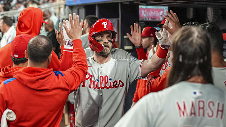 Apr 9, 2025; Cumberland, Georgia, USA; Philadelphia Phillies first base Bryce Harper (3) reacts in the dugout after hitting a two run home run against the Atlanta Braves during the seventh inning at Truist Park.