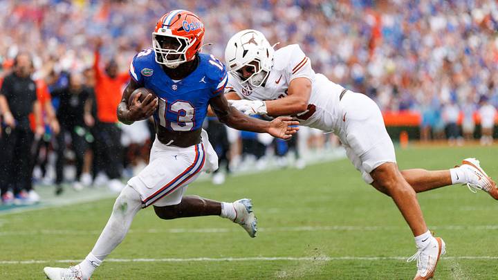Florida Gators running back Jadan Baugh (13) breaks a tackle from Texas Longhorns linebacker Liona Lefau (18) during the first half at Ben Hill Griffin Stadium. 
