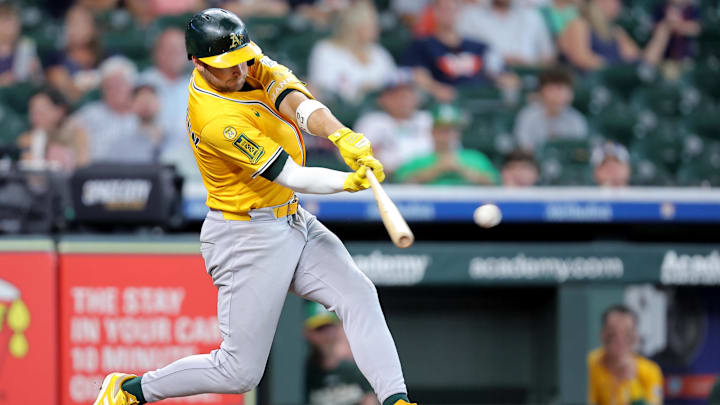 Jul 27, 2025; Houston, Texas, USA; Athletics shortstop Max Schuemann (12) hits a RBI single against the Houston Astros during the ninth inning at Daikin Park. Mandatory Credit: Erik Williams-Imagn Images