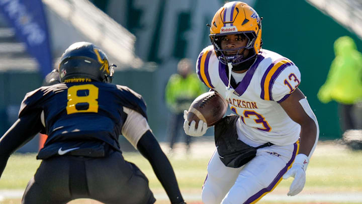 Dec 6, 2024; Birmingham, AL, USA; Jackson's Ezavier Crowell (13) tries to evade a tackle by Cherokee County's Tyson Wood (8) at Protective Stadium in the AHSAA 4A State Championship game.