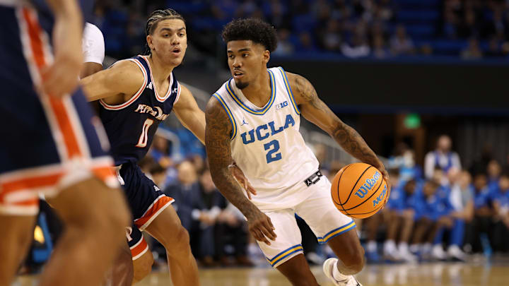 Nov 7, 2025; Los Angeles, California, USA;  UCLA Bruins guard Donovan Dent (2) dribbles the ball around Pepperdine Waves guard Styles Phipps (0) during the first half at Pauley Pavilion presented by Wescom Financial. Mandatory Credit: Kiyoshi Mio-Imagn Images