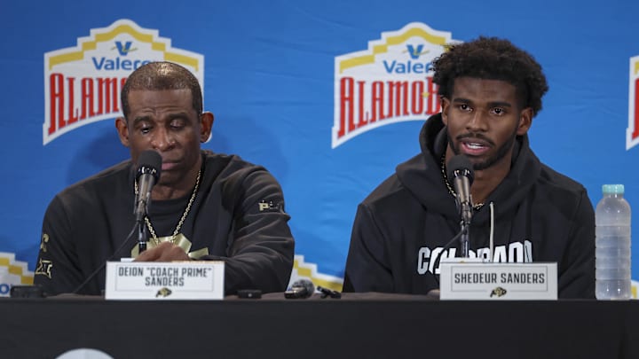 Dec 28, 2024; San Antonio, TX, USA; Colorado Buffaloes head coach Deion Sanders and quarterback Shedeur Sanders (2) talk with the media after the game against the Brigham Young Cougars at Alamodome. Mandatory Credit: Troy Taormina-Imagn Images