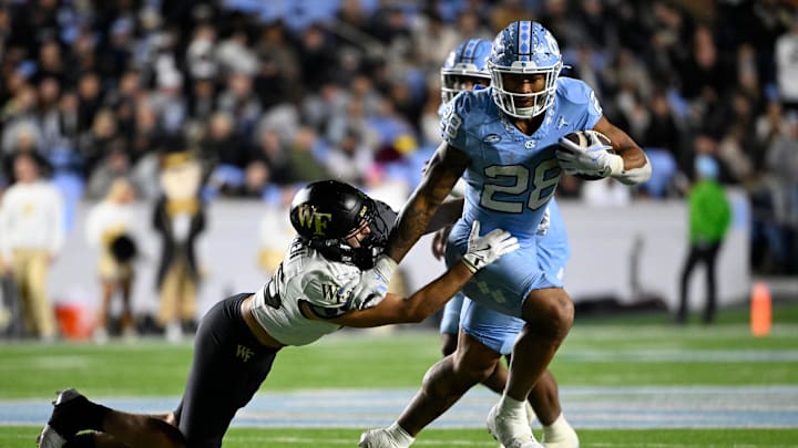 Nov 16, 2024; Chapel Hill, North Carolina, USA; North Carolina Tar Heels running back Omarion Hampton (28) runs as Wake Forest Demon Deacons defensive back Nick Andersen (45) defends in the third quarter at Kenan Memorial Stadium. Mandatory Credit: Bob Donnan-Imagn Images Nov 16, 2024; Chapel Hill, North Carolina, USA; North Carolina Tar Heels running back Omarion Hampton (28) runs as Wake Forest Demon Deacons defensive back Nick Andersen (45) defends in the third quarter at Kenan Memorial Stadium. Mandatory Credit: Bob Donnan-Imagn Images