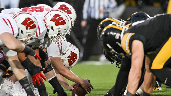 The line of scrimmage between the Iowa Hawkeyes and the Wisconsin Badgers. The line of scrimmage between the Iowa Hawkeyes and the Wisconsin Badgers.