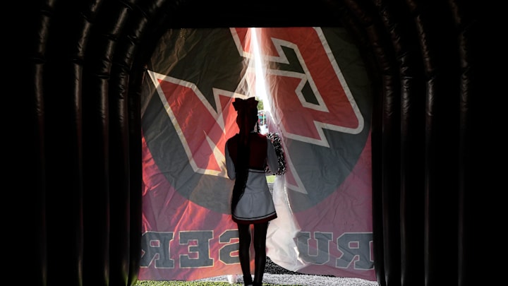 August 23, 2024; Groveport, Ohio, USA; 
A Groveport Madison cheerleader peeks out from the team’s tunnel before Friday night’s game against Hilliard Bradley on Le’Veon Bell Field at Cruiser Stadium.