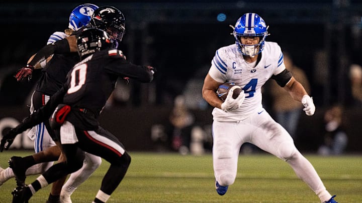 BYU Cougars running back LJ Martin (4) runs the ball as Cincinnati Bearcats cornerback Matthew McDoom (0) defends in the third quarter of the NCAA football game at Nippert Stadium in Cincinnati on Nov. 22, 2025.