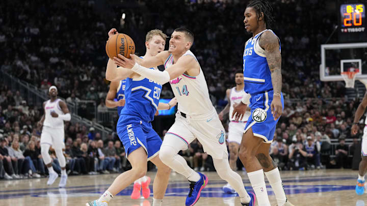 Feb 23, 2025; Milwaukee, Wisconsin, USA;  Miami Heat guard Tyler Herro (14) drives for the basket between Milwaukee Bucks guards AJ Green (20) and Kevin Porter Jr. (3) during the fourth quarter at Fiserv Forum. Mandatory Credit: Jeff Hanisch-Imagn Images