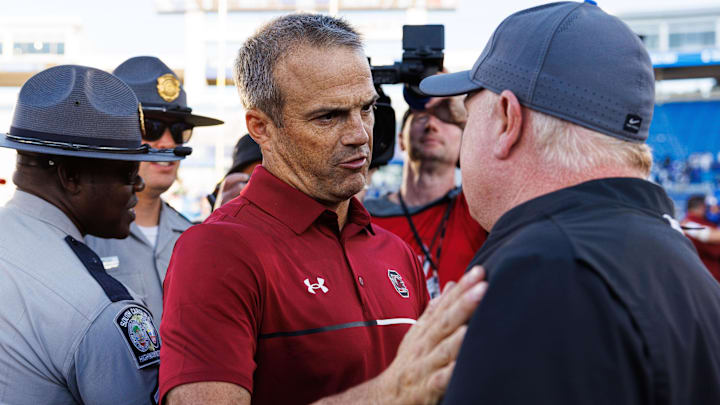 Sep 7, 2024; Lexington, Kentucky, USA; South Carolina Gamecocks head coach Shane Beamer talks with Kentucky Wildcats head coach Mark Stoops after the game at Kroger Field. Mandatory Credit: Jordan Prather-Imagn Images
