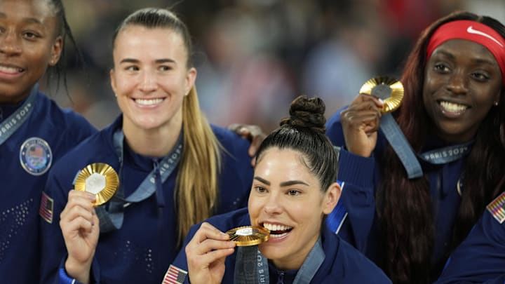 Aug 11, 2024; Paris, France; United States guard Kelsey Plum (5) celebrates with guard Sabrina Ionescu (6) and forward Kahleah Copper (7) after defeating France in the women's gold medal game during the Paris 2024 Olympic Summer Games at Accor Arena. Mandatory Credit: Kyle Terada-Imagn Images