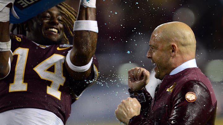 Dec 28, 2021; Phoenix, AZ, USA; Minnesota Golden Gophers head coach P. J. Fleck reacts as he is doused with Powerade by Minnesota Golden Gophers linebacker Braelen Oliver (14) during the second half against the West Virginia Mountaineers at Chase Field. Mandatory Credit: Joe Camporeale-Imagn Images
