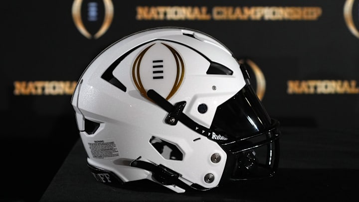 A College Football Playoff logo helmet at a press conference