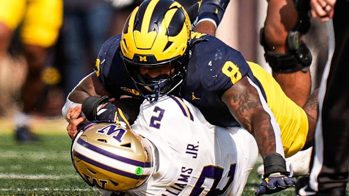 Michigan edge Derrick Moore (8) sacks Washington quarterback Demond Williams Jr. (2) during the first half at Michigan Stadium in Ann Arbor on Saturday, Oct. 18, 2025.