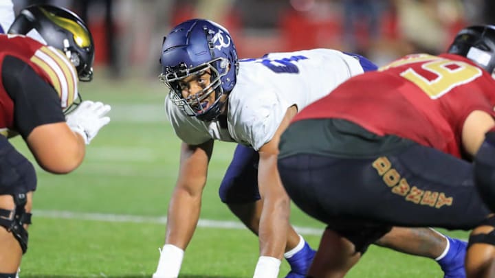 Richie Wesley (blue) lines up at the line of scrimmage against Downey.