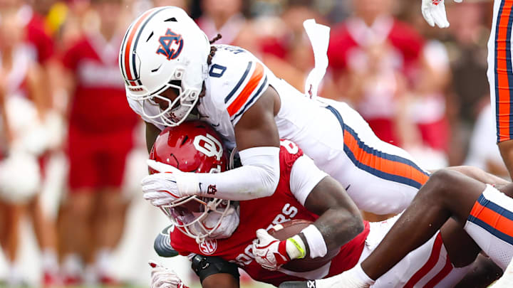 Sep 20, 2025; Norman, Oklahoma, USA;  Auburn Tigers linebacker Robert Woodyard Jr. (0) tackles Oklahoma Sooners running back Tory Blaylock (6) during the first half at Gaylord Family-Oklahoma Memorial Stadium. Mandatory Credit: Kevin Jairaj-Imagn Images